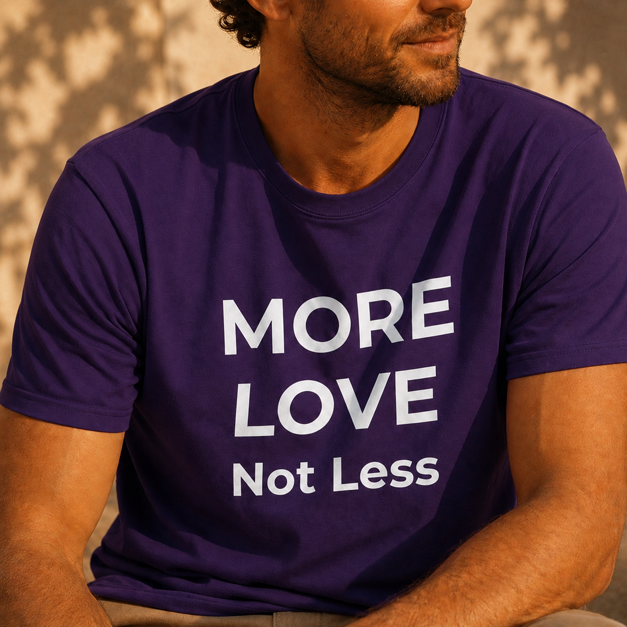Person wearing a purple t-shirt with 'MORE LOVE Not Less' text.